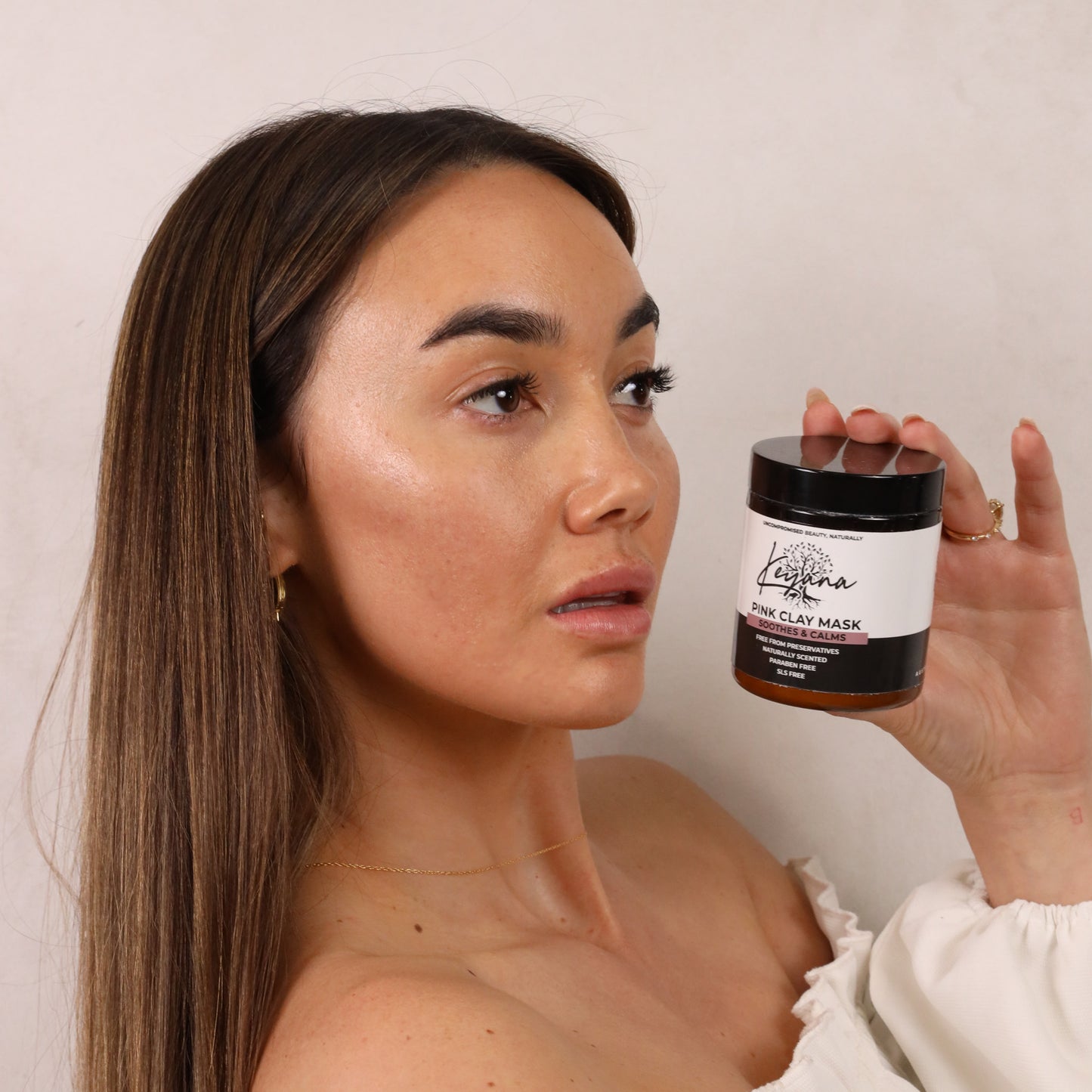 Model holding Keyana Pink Clay Mask – rejuvenating mask that gently exfoliates and nourishes the skin for a fresh, glowing complexion.